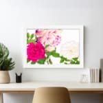 Infidu Vintage Floral Wall Art with pink, cream, and white flowers, green leaves, and a white frame on a white background. displayed on the wall