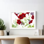 Vintage floral wall art with red and purple trumpet flowers, green leaves, and a white frame on a white background. displayed on the wall