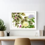 Vintage floral wall art with soft yellow and light purple flowers, green leaves with dark veins, and a white background. displayed on the wall in a white frame