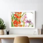 Vintage floral wall art with bright orange and soft pink flowers, green leaves, and a white frame on a white background. displayed on the wall