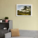Vintage wall art of a serene forest with sunlight streaming through trees and distant hills in the background. displayed on the wall in a white frame