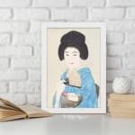 Vintage art of a Japanese woman in a light blue kimono holding a fan with a calm expression and soft background. displayed on the wall in a white frame