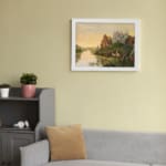Dreamy vintage river landscape with deer, two castles, and a golden sky in a peaceful fairytale setting. displayed on the wall in a white frame