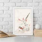 Vintage wall art with a bird surrounded by delicate flowers and plants in soft greens, reds, and whites, framed in white. displayed on the wall