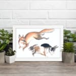 Infidu vintage wall art featuring a playful illustration of a jumping fox and two running rabbits in soft, natural colors against a clean white background. displayed on the wall art in a white frame