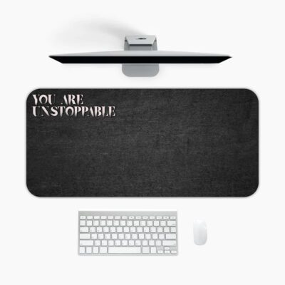 Infidu black desk pad with bold white "YOU ARE UNSTOPPABLE" text on a textured black background.