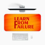 Infidu desk pad with bold red "Learn From Failure" quote on an orange to red gradient background.