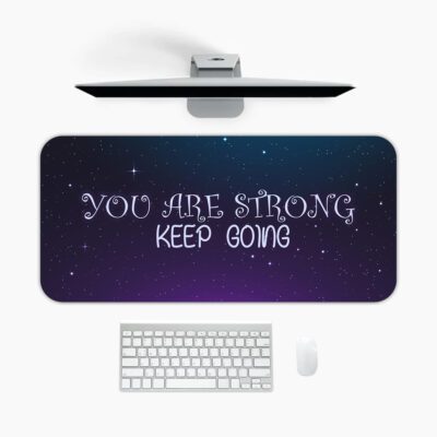 Infidu galaxy desk pad with “YOU ARE STRONG KEEP GOING” quote on a blue to purple starry background.