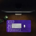 Infidu desk pad with bold “Keep Pushing Forward” quote on purple background and vintage art-inspired design.