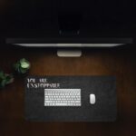 Infidu black desk pad with bold white "YOU ARE UNSTOPPABLE" text on a textured black background.