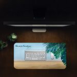 Infidu beach desk pad with tropical leaves and Isaiah 41:10 Bible verse on a soft sky and sand background.