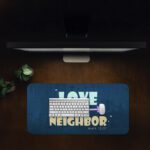 Infidu navy desk pad with “Love Your Neighbor” Bible verse in colorful vintage lettering on a textured blue background.