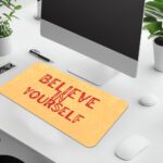 Infidu desk pad with bold red Believe in Yourself text on a soft yellow background and subtle vintage texture.