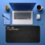 Infidu black desk pad with bold white "YOU ARE UNSTOPPABLE" text on a textured black background.