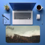 Infidu Misty Mountain Desk Pad featuring forested hills with fog, earthy colors, and the inspirational quote "Live as love did, and be made in love."