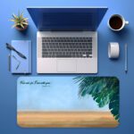 Infidu beach desk pad with tropical leaves and Isaiah 41:10 Bible verse on a soft sky and sand background.