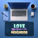 Infidu navy desk pad with “Love Your Neighbor” Bible verse in colorful vintage lettering on a textured blue background.