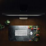 Infidu desk pad with wooden cross, red flowers, and Matthew 19:26 Bible verse on a gray gradient background.