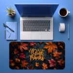 Vintage-style autumn desk pad with colorful fall leaves, acorns, and "Give Thanks" in golden-yellow calligraphy on a dark background.