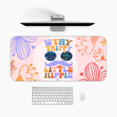 Groovy desk pad with “Stay Trippy Little Hippie” quote, bold floral background, cartoon mustache, and sunglasses in vintage art style.