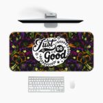 Dark floral desk pad with kaleidoscope pattern in purple, green, and orange, featuring “Just Do Good” quote in white framed text, vintage art style.