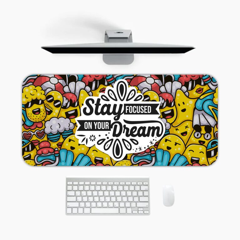 Colorful doodle-style desk pad with cartoon characters and “Stay Focused On Your Dream” quote in black text on a white cloud-like shape.