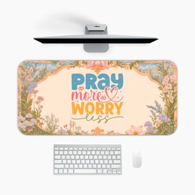 Desk pad with pastel floral border and colorful “Pray More, Worry Less” quote on a warm cream background in vintage art style.