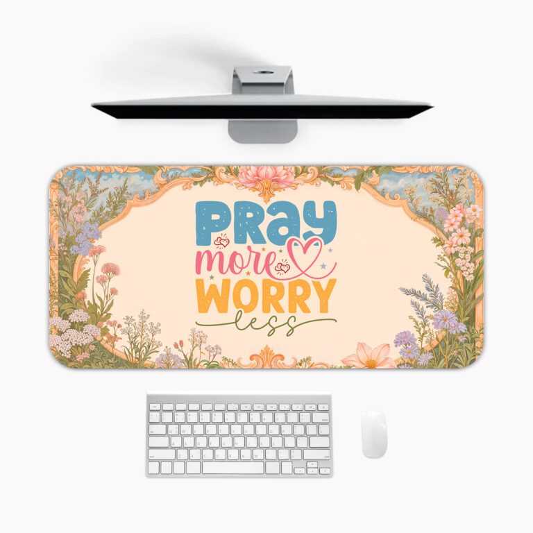 Desk pad with pastel floral border and colorful “Pray More, Worry Less” quote on a warm cream background in vintage art style.