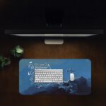 Infidu blue desk pad with mountain cross and uplifting quote on serene background.
