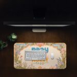 Desk pad with pastel floral border and colorful “Pray More, Worry Less” quote on a warm cream background in vintage art style.