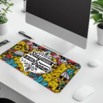 Colorful doodle-style desk pad with cartoon characters and “Stay Focused On Your Dream” quote in black text on a white cloud-like shape.
