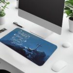 Infidu blue desk pad with mountain cross and uplifting quote on serene background.