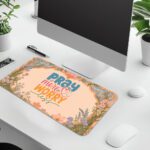 Desk pad with pastel floral border and colorful “Pray More, Worry Less” quote on a warm cream background in vintage art style.