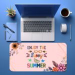 Pastel pink desk pad with floral corners, playful “Enjoy the Sunny Summer” text, sunglasses, sun rays, and vintage art style accents.