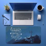 Infidu blue desk pad with mountain cross and uplifting quote on serene background.