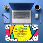 Colorful comic-style desk pad with bold triangular shapes, cartoon clouds, and “Be Strong and Courageous” Bible verse in vintage art style.